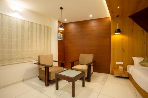a bedroom with a bed and a table and chairs at Hasco Tower in Palakkad