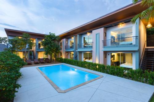 an exterior view of a house with a swimming pool at Parida Resort in Bang Tao Beach