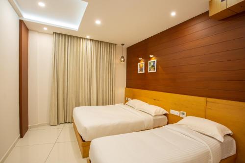 a hotel room with two beds and a window at Hasco Tower in Palakkad
