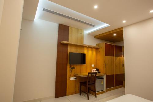 a kitchen with a table and a tv in a room at Hasco Tower in Palakkad