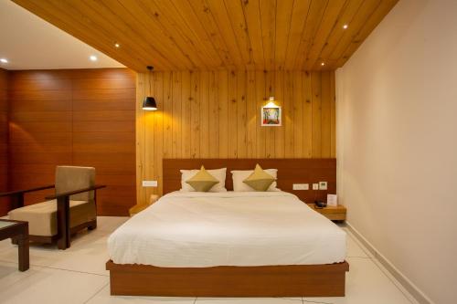 a bedroom with a bed and a desk and a chair at Hasco Tower in Palakkad