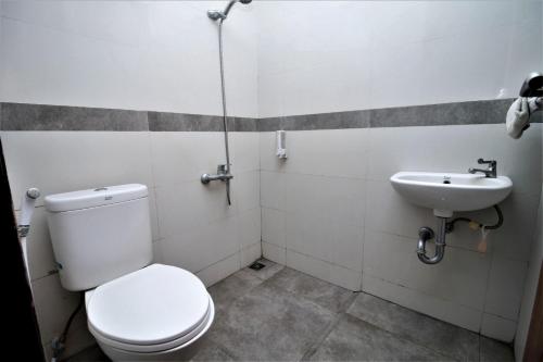 a bathroom with a toilet and a sink at Bale Resident in Jakarta