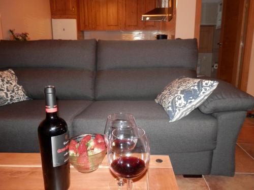a bottle of wine and two glasses on a table at Casa Rural El Dolmen in Bernúy-Salinero