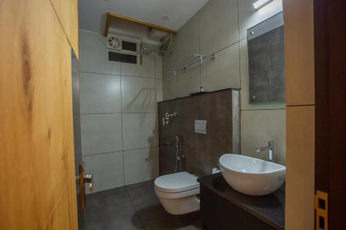 a bathroom with a white toilet and a sink at Hasco Tower in Palakkad