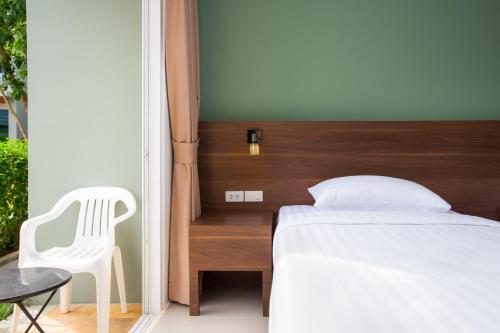 a bedroom with a bed and a chair and a table at Parida Resort in Bang Tao Beach
