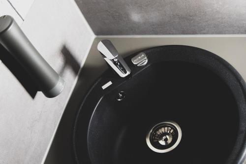a black sink with a faucet in a bathroom at Das Schlafwerk Stuttgart-Nord VOLLDIGITALES HOTEL-SELF-CHECK IN - keine Rezeption-LowBudget-cashless in Korntal-Münchingen