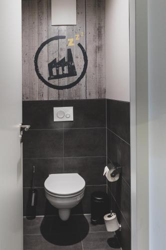 a bathroom with a toilet and a sign on the wall at Das Schlafwerk Stuttgart-Nord VOLLDIGITALES HOTEL-SELF-CHECK IN - keine Rezeption-LowBudget-cashless in Korntal-Münchingen