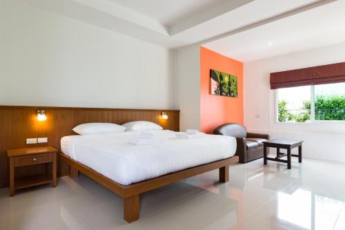 a bedroom with a large white bed and a window at Parida Resort in Bang Tao Beach