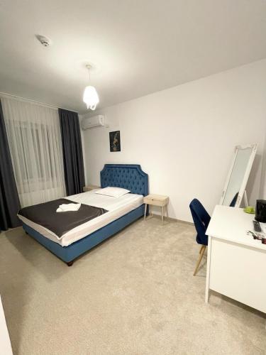 a bedroom with a bed and a desk in it at COCHET BOUTIQUE in Târgu Jiu