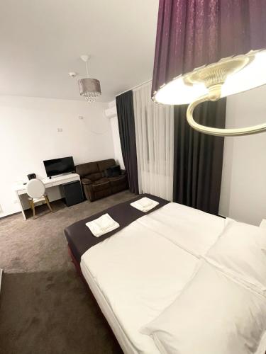 a bedroom with a bed and a living room at COCHET BOUTIQUE in Târgu Jiu