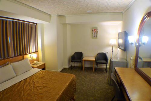a hotel room with a bed and a desk and chairs at Lo Fo Hotel in Taichung