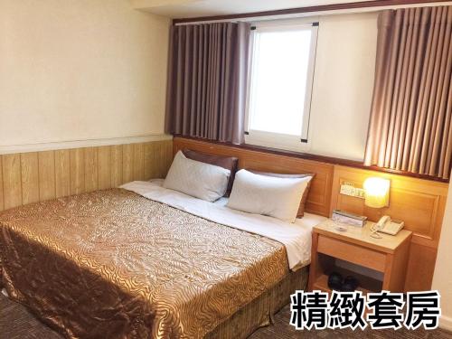 a hotel room with a bed and a window at Lo Fo Hotel in Taichung