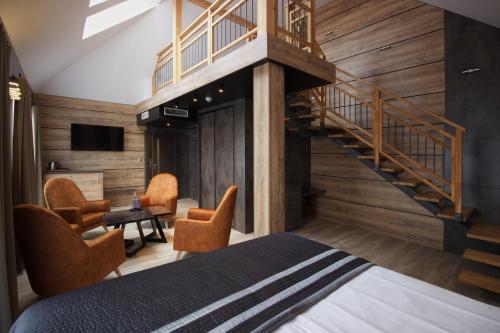 a bedroom with a staircase and a bed with chairs at Aparton in Ustka