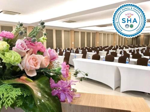 a vase of flowers on a table in a room at S Bangkok Hotel, Navamin in Ban Khi Sua
