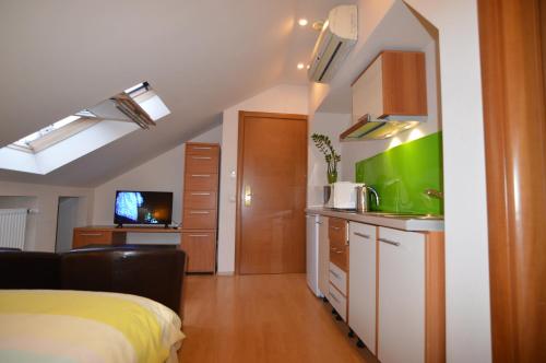 a room with a bed and a kitchen with a sink at GrandVille Apartments in Bucharest