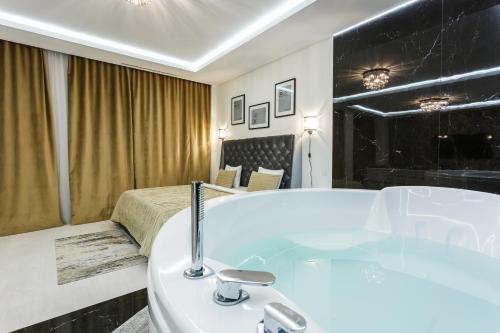 a bathroom with a bath tub and a bed at Апартаменты Гостиный Дом in Minsk