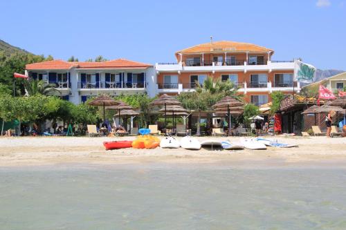 a hotel on a beach with surfboards and umbrellas at Nefeli Wind Club in Vasiliki