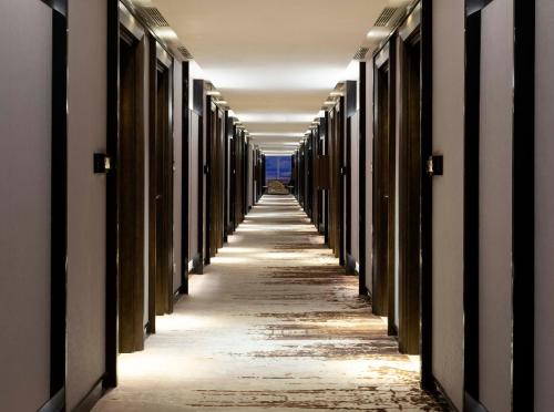 an empty hallway of a building with a long corridor at GRAMM HOTEL by Ambarrukmo Yogyakarta in Yogyakarta