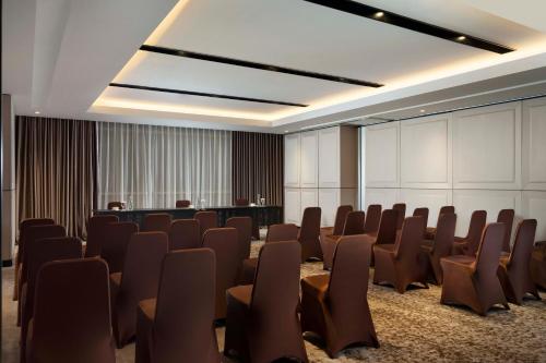 a conference room with chairs and a podium at GRAMM HOTEL by Ambarrukmo Yogyakarta in Yogyakarta
