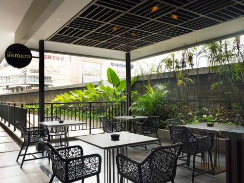 a restaurant with tables and chairs and a patio at GRAMM HOTEL by Ambarrukmo Yogyakarta in Yogyakarta