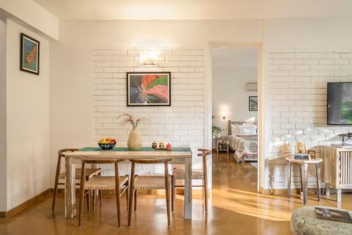 a dining room and living room with a table at La Mer Apartments - 10 mins Drive to Candolim Beach - 20 mins from Panjim in Nerul