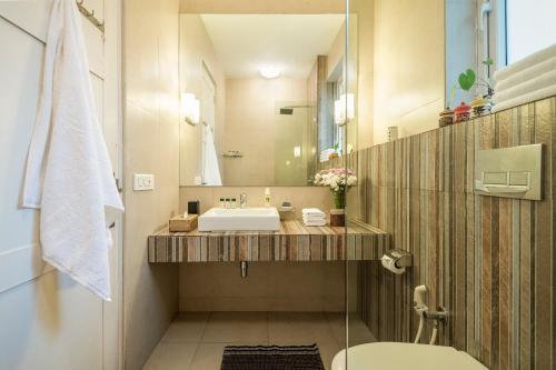 a bathroom with a sink and a mirror at La Mer Apartments - 10 mins Drive to Candolim Beach - 20 mins from Panjim in Nerul