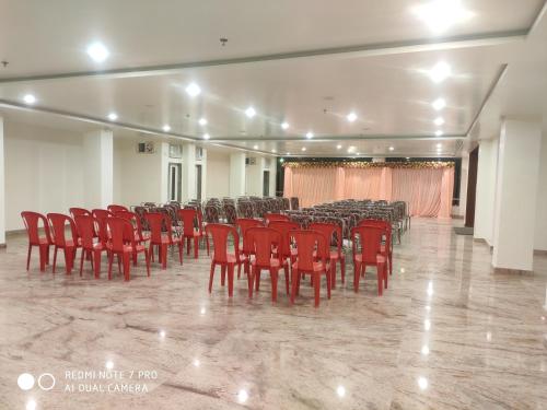 a room with a bunch of red chairs and tables at Hotel Shree Shyam International in Bilāspur
