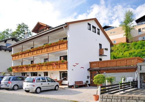 un edificio bianco con auto parcheggiate di fronte di Haus Iris a Bodenmais