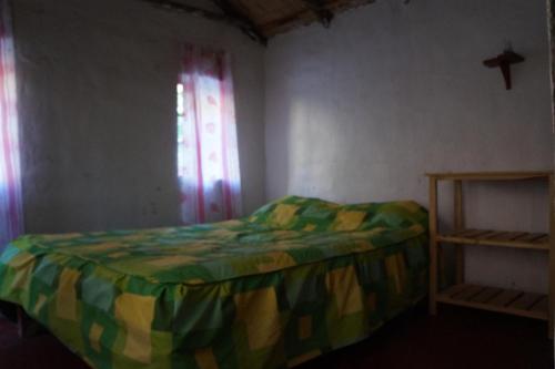a small bedroom with a bed and a window at Paraiso Las Palmeras Lodge in Cabanaconde