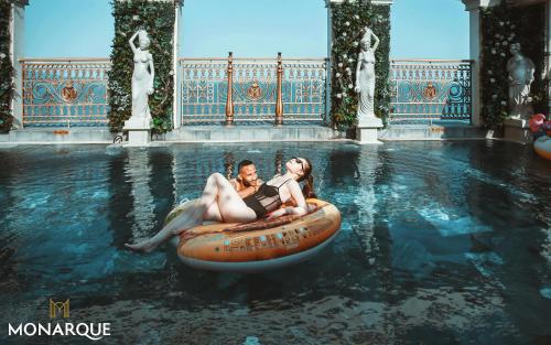 a man and a woman riding on anlatable raft in the water at Monarque Hotel Danang in Da Nang