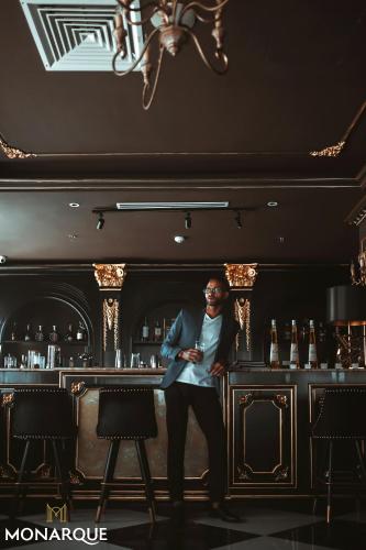 a man standing in front of a bar at Monarque Hotel Danang in Da Nang