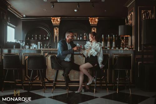 a man and a woman sitting at a bar at Monarque Hotel Danang in Da Nang