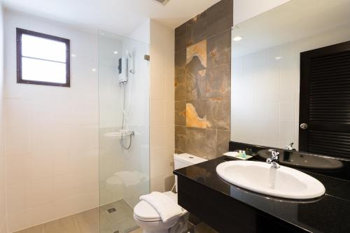 a bathroom with a sink and a toilet and a shower at Parida Resort in Bang Tao Beach