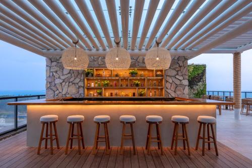 a bar with stools and a view of the ocean at 1 Hotel Haitang Bay, Sanya in Sanya