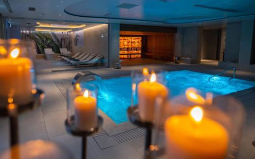 a pool with lit candles and a group of lit candles at Hotel Belmont & Spa in Sinaia