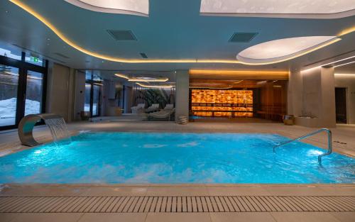 a large swimming pool in a hotel lobby at Hotel Belmont & Spa in Sinaia