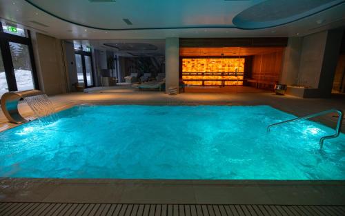 a large blue swimming pool in a hotel room at Hotel Belmont & Spa in Sinaia