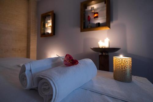 a hotel room with a towel on a bed with candles at Hotel Belmont & Spa in Sinaia