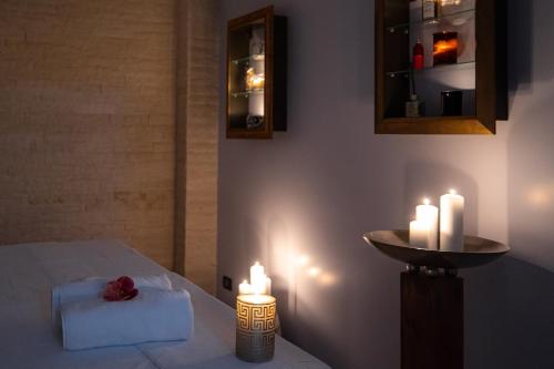 a room with a bed with two candles and a sink at Hotel Belmont & Spa in Sinaia