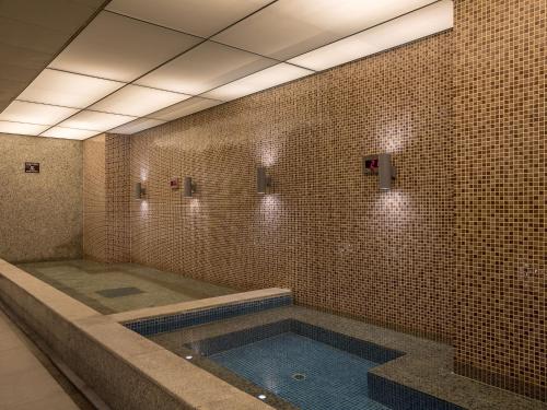 a swimming pool in a bathroom with a tile wall at LOTTE Hotel Serviced Apartment in Yangon