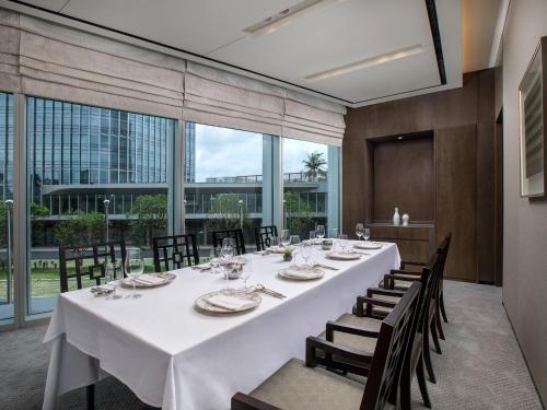 a dining room with a long table and chairs at LOTTE Hotel Serviced Apartment in Yangon