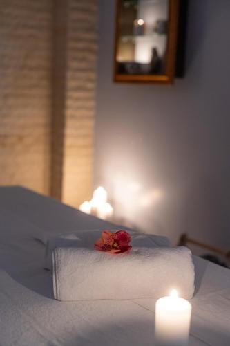 a red rose on top of a bed with a candle at Hotel Belmont & Spa in Sinaia