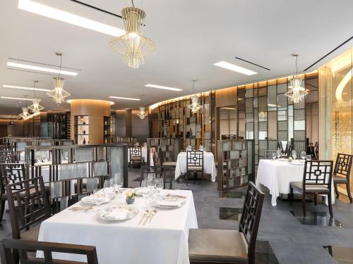 a dining room with white tables and chairs at LOTTE Hotel Serviced Apartment in Yangon