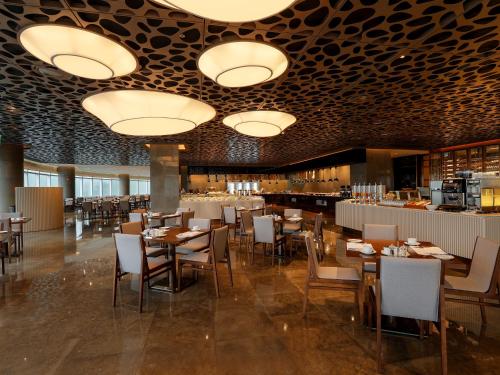 a dining room with tables and chairs and lights at LOTTE Hotel Serviced Apartment in Yangon
