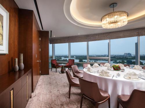 a dining room with a table and chairs and windows at LOTTE Hotel Serviced Apartment in Yangon