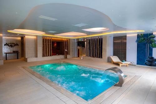 a large swimming pool in a hotel room at Hotel Belmont & Spa in Sinaia