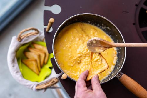 a person is holding a pan with a spoon at Hotel Belmont & Spa in Sinaia