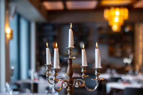 a candlestick with lit candles in a restaurant at Hotel Belmont & Spa in Sinaia