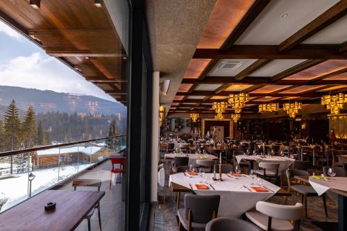 a restaurant with tables and chairs and a large window at Hotel Belmont & Spa in Sinaia