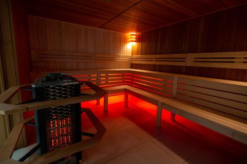 a sauna with red lighting and a wine rack at Hotel Belmont & Spa in Sinaia